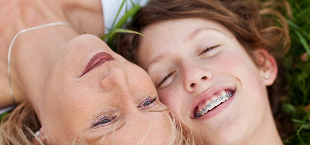 Mamma e figlia in cura con l'ortodonzia sorridono